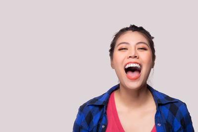 Portrait of smiling young woman against white background