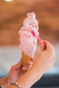 Cropped hand holding ice cream cone