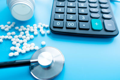 High angle view of stethoscope with calculator on table