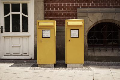 Yellow mailboxes against building