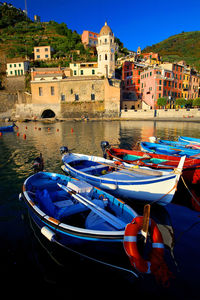 Boats moored in canal by buildings in city