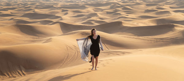 Rear view of woman walking in desert