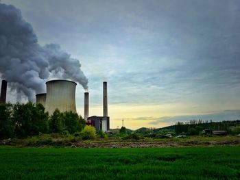 View of grassy field against cloudy sky