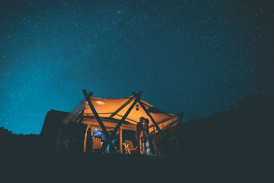 Low angle view of illuminated tent against sky at night