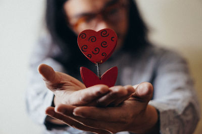 Midsection of woman holding heart shape