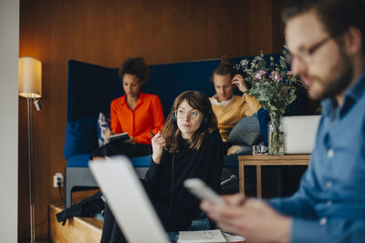 Group of people using phone while sitting on table