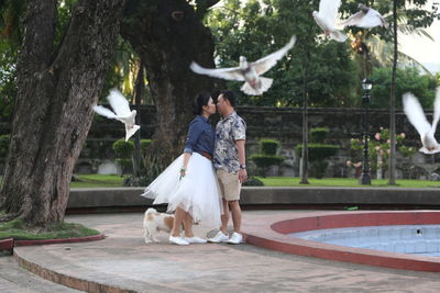 Couple kissing while standing in park