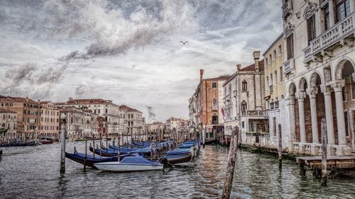 Boats moored in canal with buildings in background