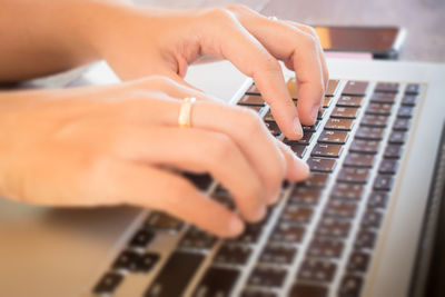 Cropped image of woman using laptop