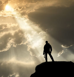 Silhouette of friends against mountain during sunset