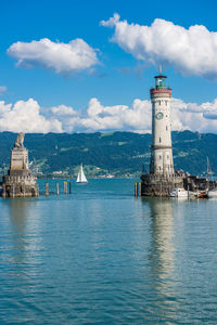 Lighthouse by sea against sky