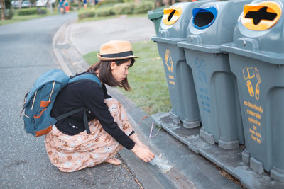 Woman collecting garbage on road