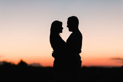 Silhouette couple kissing at sunset