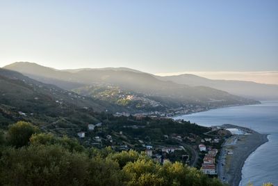 High angle view of cityscape by sea against clear sky