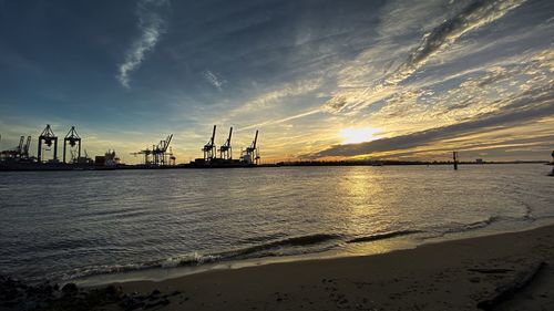 Silhouette pier over sea against sky during sunset