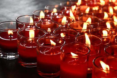 Close-up of lit tea light candles on table in building