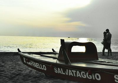 People on boat in sea against sky