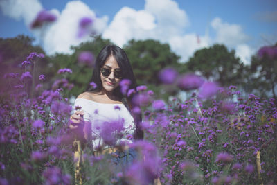 Woman amidst purple flowers on field