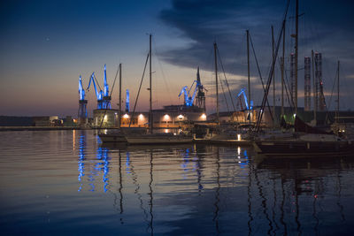 Sailboats moored in harbor at night