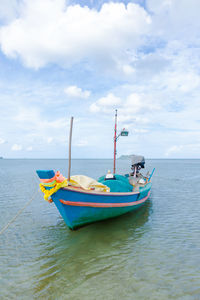 Rowboat in sea against sky