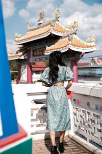 Rear view of woman standing against building