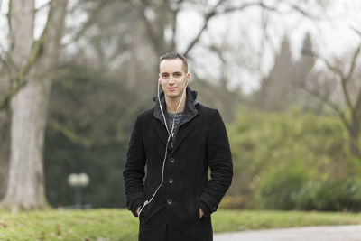 Portrait of young man standing against plants