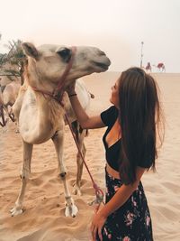 Full length of woman with horse in background