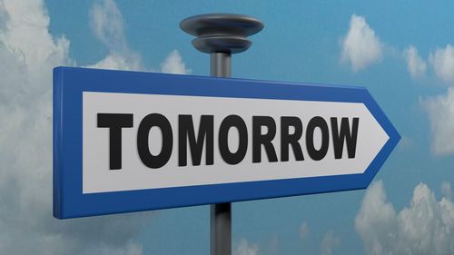 Low angle view of sign against blue sky