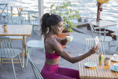 Young woman sitting on chair at table