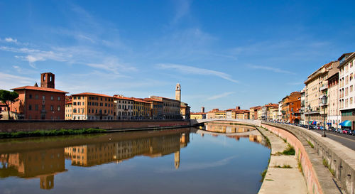 Reflection of buildings in canal against sky