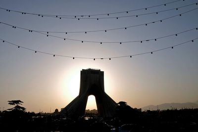Silhouette azadi tower at against clear sky during sunset