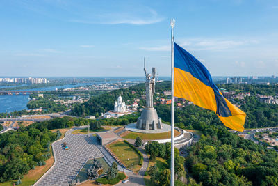 Aerial view of the ukrainian flag waving in the wind against the city of kyiv