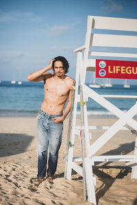 Portrait of shirtless man standing on beach