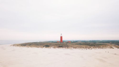 Lighthouse texel by sea against sky