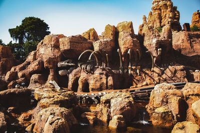Dinosaur bone on rock formations against clear sky