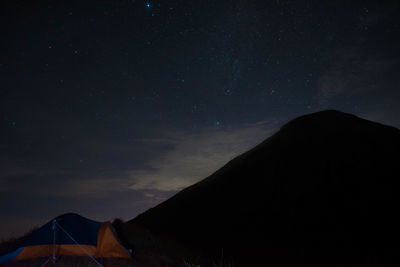 Scenic view of silhouette mountains against sky at night