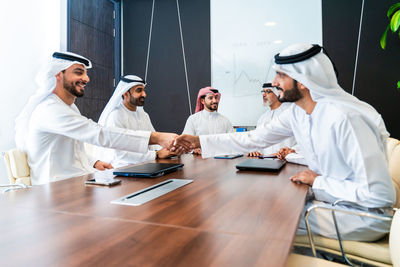 Female friends using digital tablet in office