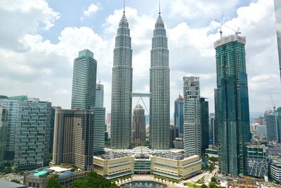 Skyscrapers in city against cloudy sky