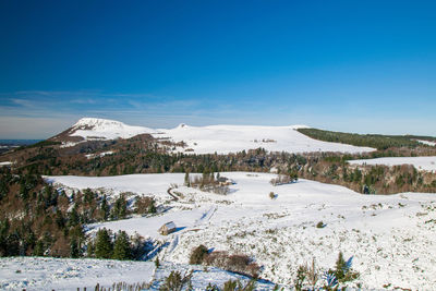 Scenic view of snowcapped mountains against blue sky