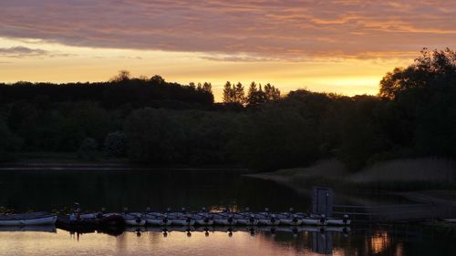 Scenic view of river against sky at sunset