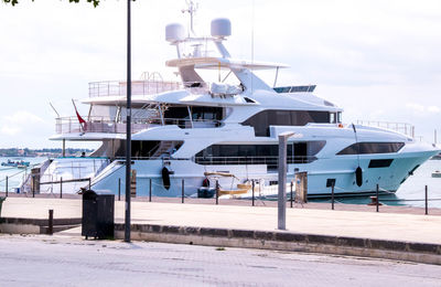 Boats moored at harbor against sky