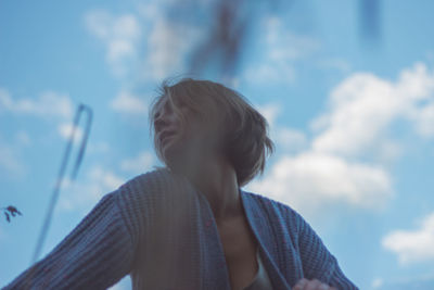 Low angle portrait of boy against sky