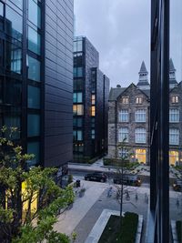 Buildings by street in city against sky