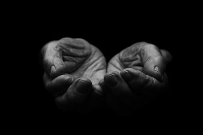 Close-up of hands against black background