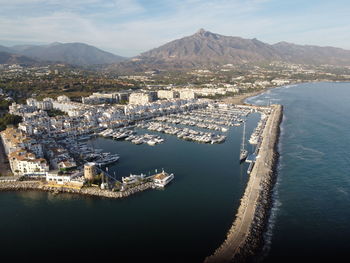 High angle view of city by sea against sky