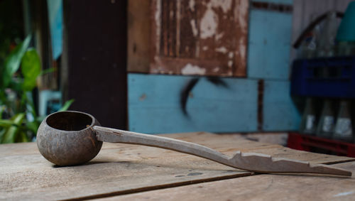 Close-up of old wooden table against building