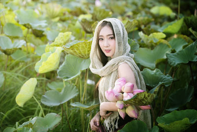 Portrait of young woman with plants