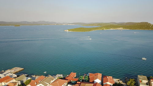 High angle view of town by sea against sky