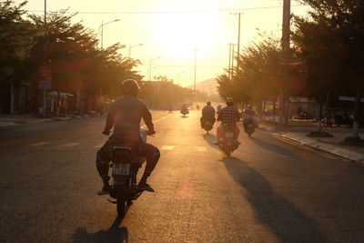 Rear view of man riding motorcycle on street
