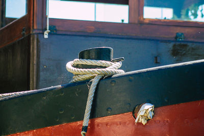 Close-up of rope tied on metal window